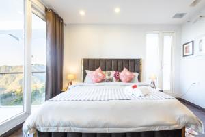 ein Schlafzimmer mit einem großen Bett und einem großen Fenster in der Unterkunft Hostie Imperial Chalet-3 BHK Mountain Villa, Chail in Shimla