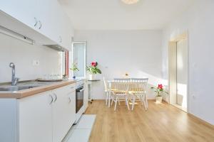 a kitchen with white cabinets and a table with chairs at Apartment Mare in Dubrovnik