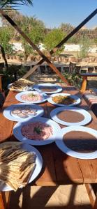 a wooden table with plates of food on it at Santarya hotel in Siwa
