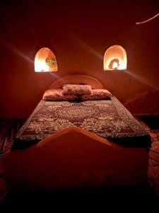 a bedroom with a bed with two lights on it at Santarya hotel in Siwa