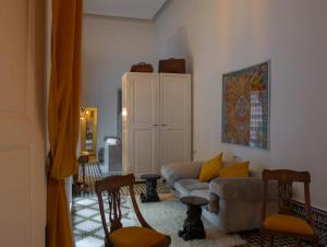 sala de estar con sofá y algunas sillas en Riad Palais Bahia Fes, en Fez