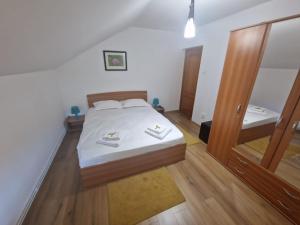 una camera da letto con un letto con lenzuola bianche e uno specchio di Casa La Buni a Buşteni