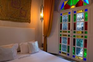 a bedroom with a bed and a stained glass window at Riad Palais Bahia Fes in Fez