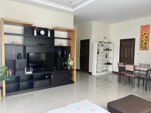 un salon avec une télévision et une salle à manger dans l'établissement Huahin asset pool villa, à Hua Hin