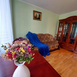 a living room with a couch and a vase of flowers at новобуд 2 кімнати Вернадського 8 in Lviv