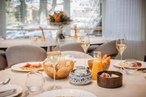 una mesa con platos de comida y copas de vino en B&B Roosendaelhof en Geel