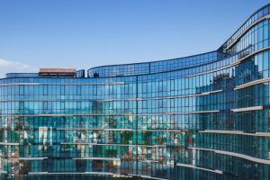 un edificio de cristal alto con un tren en él en Paragraph Freedom Square, a Luxury Collection Hotel, Tbilisi en Tiflis