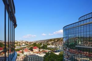Paragraph Freedom Square, a Luxury Collection Hotel, Tbilisi في تبليسي: اطلالة على المدينة من مبنى زجاجي