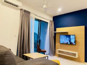 ein Wohnzimmer mit einem Sofa und einem TV in der Unterkunft Hygge Living@Sunway Onsen in Tambun