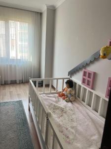 ein kleines Kind in einem Kinderbett in einem Schlafzimmer in der Unterkunft BABİLON REZİDANS APARTMANI in Rize