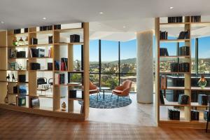 a library with bookshelves and a view of the city at Paragraph Freedom Square, a Luxury Collection Hotel, Tbilisi in Tbilisi City