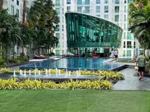 a fountain in front of a building with people walking around it at City Center Residence in Pattaya Central