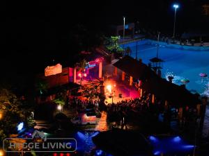 Eine Menschenmenge, die nachts in der Nähe eines Pools steht. in der Unterkunft Hygge Living@Sunway Onsen in Tambun