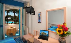 Habitación de hotel con escritorio y ordenador portátil. en Hotel Villa Hermosa, en Isquia
