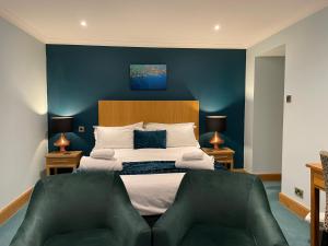 a bedroom with a large bed with a blue wall at The Ship Inn in Gatehouse of Fleet