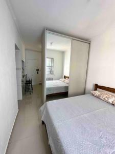 a bedroom with two beds and a mirror at Apto 50m da praia Gonzaguinha São Vicente Edifício Estrela do Mar in São Vicente