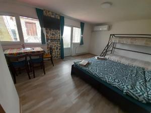 a bedroom with a bed and a dining room with a table at Apartment Matej in Kruševo