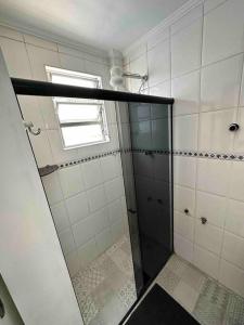 a bathroom with a shower with a glass door at Apto 50m da praia Gonzaguinha São Vicente Edifício Estrela do Mar in São Vicente