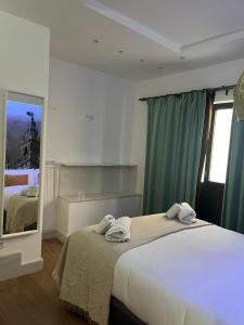een slaapkamer met een groot bed en handdoeken bij Deluxe Artemisa Sevilla in Sevilla