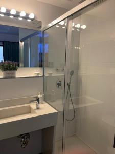 een badkamer met een douche, een wastafel en een spiegel bij Deluxe Artemisa Sevilla in Sevilla