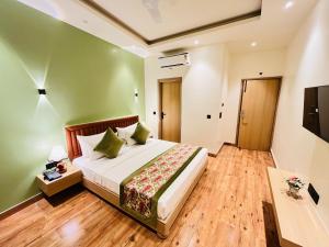 a bedroom with a bed with a green wall at Hotel IP Swarn near Anand Vihar Vaishali Ghaziabad in Ghaziabad