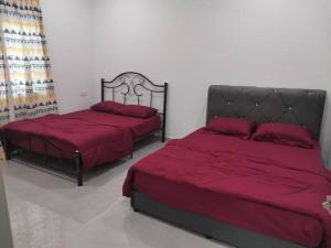 two beds with red sheets in a bedroom at D'Parking Homestay Klia Sepang Budget Murah in Banting