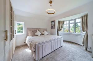 a bedroom with a bed and a large window at Luxury Hot Tub Home Torquay in Torquay