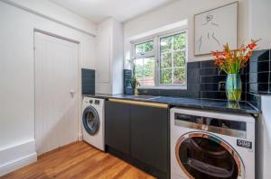 een wasruimte met een wasmachine en droger bij Luxury Hot Tub Home Torquay in Torquay