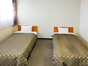 Een bed of bedden in een kamer bij Hotel Kurashiki Mizushima Hills