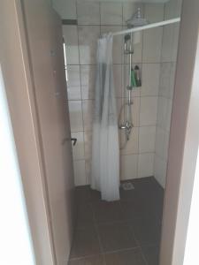a shower with a white shower curtain in a bathroom at Apartment Matej in Kruševo