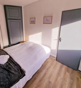 um quarto com uma cama branca e piso em madeira em "Le Bisontin", studio cosy au calme, proche de la gare em Besançon