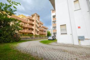 un edificio con un coche estacionado junto a una carretera de ladrillo en Agenzia Vear - Lido degli Scacchi, en Lido di Pomposa