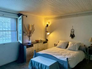een slaapkamer met een bed en een raam bij Studio calme tout confort in Dions
