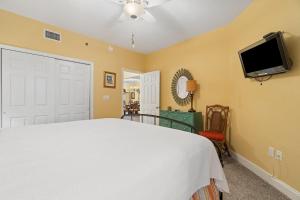 een slaapkamer met een bed en een flatscreen-tv bij Palacio 602 in Perdido Key