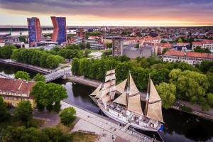 a large boat in a river in a city at Old Town Deluxe Apartment in Klaipėda