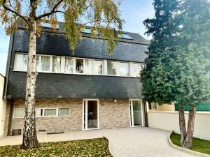 un bâtiment avec un arbre en face dans l'établissement KoalaWakeup, à Vitry-sur-Seine