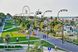 a park with people walking and a ferris wheel at Hotel Butterfly in Rimini