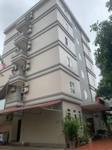 um edifício branco alto com muitas janelas em Khách Sạn Phương Thuý em Yen Bai