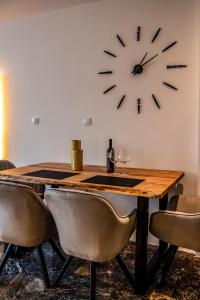 a table with chairs and a clock on the wall at Agia Sofia luxury suite & spa in Thessaloniki