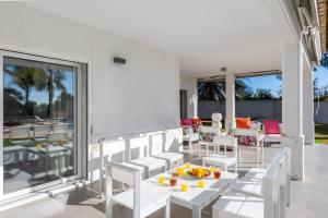 a patio with white chairs and a table with fruit on it at Luxury Villa Premium Salinas in Santa Pola