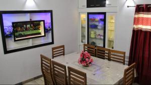 a dining room with a table with flowers on it at Kayyany's Villa - A Large Family Home in Kanjirapalli