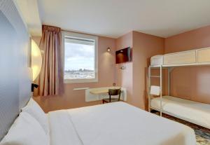sypialnia z 2 łóżkami piętrowymi i oknem w obiekcie B&B HOTEL Montluçon Saint-Victor w mieście Saint-Victor