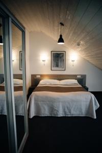 a bedroom with a large bed and a mirror at VILSON hotel in Bukovel