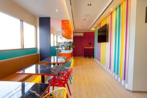ein Restaurant mit farbenfrohen Wänden, Tischen und Stühlen in der Unterkunft L'MINITEL in Chiang Mai