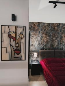 ein Schlafzimmer mit einem roten Bett und einem Gemälde an der Wand in der Unterkunft PALE-H in Bari