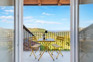 un patio con tavolo e sedie sul balcone. di Ca'd Felice - Villa nella natura con vista Langhe a Rodello