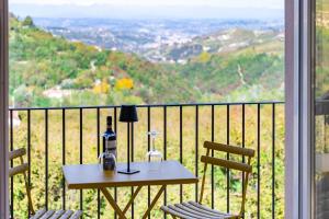 un tavolo e sedie su un balcone con vista di Ca'd Felice - Villa nella natura con vista Langhe a Rodello