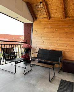 dwa czarne krzesła i stół na balkonie w obiekcie Airport Gate 25 w mieście Ledine