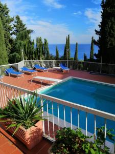una piscina en un balcón con sillas y el océano en Appartamento Addaura/Mondello, en Palermo