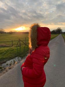 a person wearing a red jacket with a fur collar at maryam in Wittingen